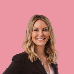 An image of Mary Kucek smiling against a soft pink background.