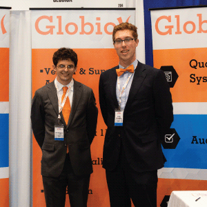 Two Globiox employees representing their sponsor at their booth, speckled with orange, blue and grey.